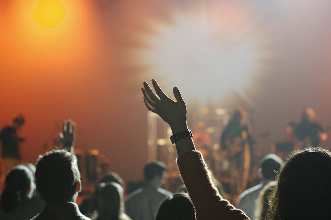 A crowd with hands raised during a worship service